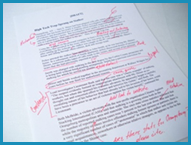 Draft of a news article covered with red editor marks and notes.