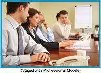 Men and women in a business meeting seated at a table.